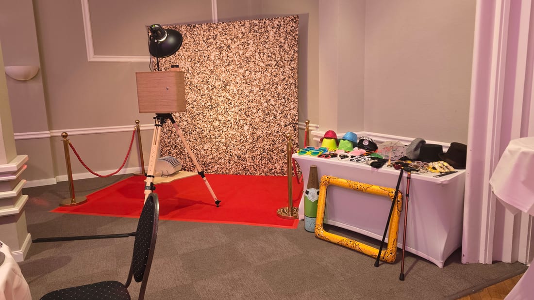 Gala-Fotobereich: roter Teppich, goldene Absperrständer, Glitzer-Hintergrund und Fotobox