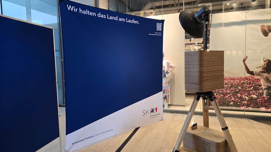 Bedruckte CI-Wand mit Claim und Logo als Messe-Hintergrund